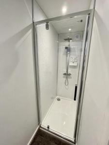 a shower with a glass door in a bathroom at Blakes Beach House Humberston Fitties in Humberston