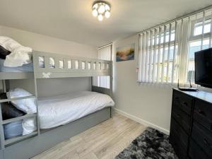 a bedroom with a bunk bed and a television at Blakes Beach House Humberston Fitties in Humberston