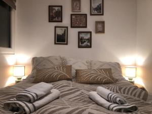 1 cama con almohadas en una habitación con 2 lámparas en Faház a kilátónál Woodhouse Lux near Kőszeg 6km Szombathely 10km Bük 20km, en Lukácsháza