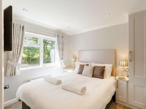 a white bedroom with a large white bed with two pillows at 2 bed property in Okehampton 86870 in Okehampton