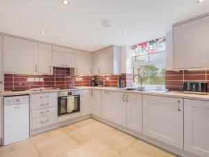 a white kitchen with white cabinets and a window at 2 Bed in Alston SZ186 in Leadgate