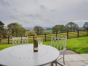 a bottle of wine on a white table with two wine glasses at 2 Bed in Alston SZ186 in Leadgate