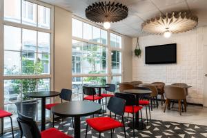 un restaurant avec des tables et des chaises et une télévision à écran plat dans l'établissement ibis Paris Ornano Montmartre Nord 18ème, à Paris