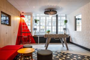 Cette chambre comprend une table de ping-pong et des chaises. dans l'établissement ibis Paris Ornano Montmartre Nord 18ème, à Paris