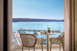 una mesa y sillas frente a una gran ventana en Aminess Younique Narrivi Hotel en Crikvenica