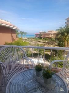 un banco blanco en un balcón con vistas al océano en Vila Maia, en Hurghada