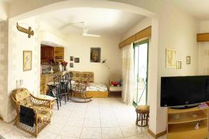 a living room with a tv and a kitchen with a couch at Concorde Royal Beach Village, Ras Sidr, South Sinai Villa 116 in Ras Sedr