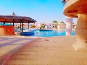 a swimming pool with a pavilion and a swimming pool at Concorde Royal Beach Village, Ras Sidr, South Sinai Villa 116 in Ras Sedr