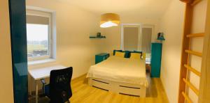 Schlafzimmer mit einem Bett, einem Schreibtisch und einem Fenster in der Unterkunft Apartmán nearly SKI ARENA in Nové Město na Moravě