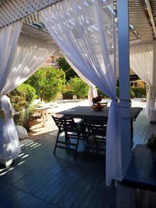 un patio con una mesa y sillas bajo un dosel blanco en Vila Maia, en Hurghada