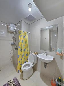 a bathroom with a toilet and a sink at Apartment Podomoro City Deli Medan in Medan
