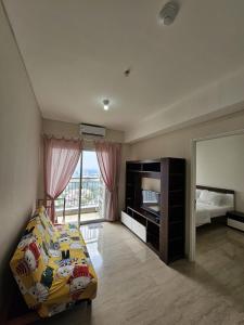 a bedroom with a bed and a large window at Apartment Podomoro City Deli Medan in Medan