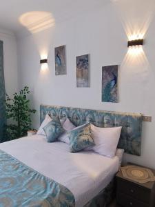 Un dormitorio con una cama con almohadas azules y blancas. en Vila Maia, en Hurghada 48 fotos más