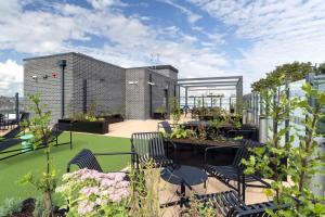 a rooftop patio with chairs and tables and plants at Stoneybatter Place in Dublin