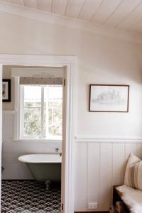 a bathroom with a bath tub and a window at MARIGOLD COTTAGE Charming 1870s central Daylesford cottage in Daylesford