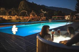 un grupo de mujeres sentadas en una bañera en una piscina en Das Falkenstein en Kaprun