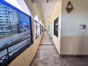 a hallway of a building with a clock on the wall at STAYMAKER Unnatha Residency in Manipal