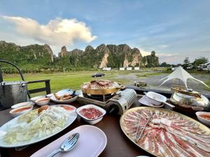 a table with plates of food on a table with mountains at วันทน่า โฮมสเตย์ บ้านมุง เนินมะปราง in Ban Mung +25 photos