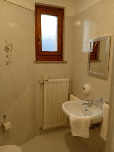 baño blanco con lavabo y ventana en HOTEL BRUSTOLON, en Dont