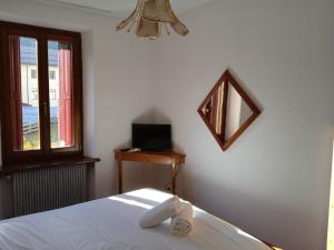 Schlafzimmer mit einem Bett, einem Spiegel und einem Fenster in der Unterkunft HOTEL BRUSTOLON in Dont