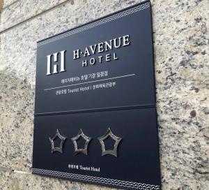 a sign for a h vienna hotel with three rings at H avenue Kijang Ilgwang in Busan