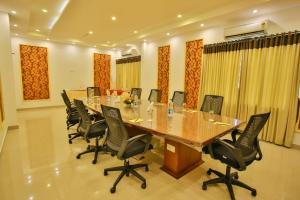 Harbour Hotels في Pallipuram: قاعة اجتماعات كبيرة مع طاولة وكراسي طويلة