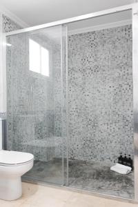 y baño con ducha de cristal y aseo. en MonKeys Apartments Lumbreras Deluxe, en Sevilla