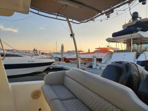 a boat with a couch on a dock with boats at A special 24 hours yacht stay in Manama