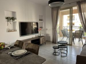 a living room with a television and a table and chairs at Royal-Seacrest Paphos-Center VIP in Paphos City