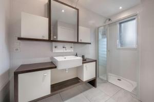 a white bathroom with a sink and a shower at Maison rénovée pour 8 - 200m Tharon plage in Tharon-Plage +19 photos