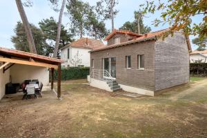 a small house with a porch and a yard at Maison rénovée pour 8 - 200m Tharon plage in Tharon-Plage