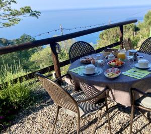 a table with food on a balcony with a view of the ocean at Villa Pietrafiore in Monterosso al Mare