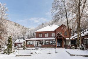a wooden house with snow on the roof at Voevodyno Resort in Turʼya Paseka