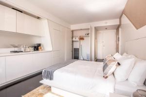 a white bedroom with a large bed and white cabinets at Financial District studio w WD gym elevator NYC-1359 in New York