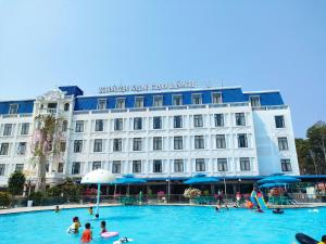 a group of people in a swimming pool in front of a hotel at Cao Lanh Hotel in Ấp Mỹ Ðông