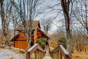 ein Haus im Wald mit einem Holzzaun in der Unterkunft The Treasure of Beech Mountain in Beech Mountain