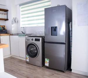 La cuisine est équipée d'un réfrigérateur et d'un lave-linge. dans l'établissement 2 Bedroom Apartment with Modern Finishes Hill Tud Stays, à Pietermaritzburg