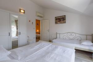 Habitación blanca con 2 camas y espejo. en Accommodation Trbovic, en Umag