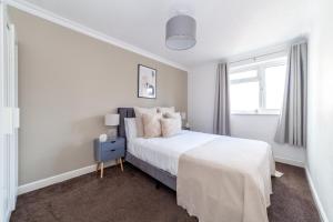 a white bedroom with a bed and a window at The Walthamstow Collection in London