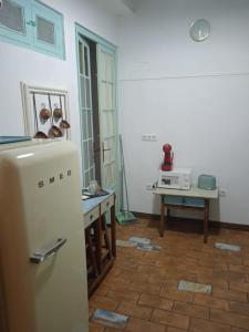 Una cocina con nevera y una mesa con microondas. en La gota de leche 4, en Sanlúcar de Barrameda