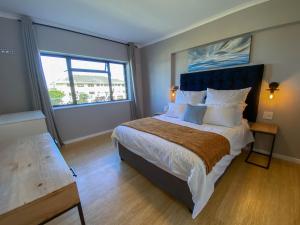 a bedroom with a large bed with a large window at Sundrenched 2 bed 2 bath apartment + sea views in Cape Town