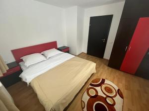 um quarto com uma cama grande e uma cabeceira vermelha em Pensiunea Valea Dorului em Fundstica