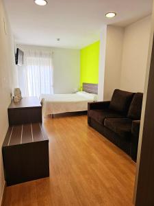 sala de estar con cama y sofá en Hotel Rocamar, en Benidorm