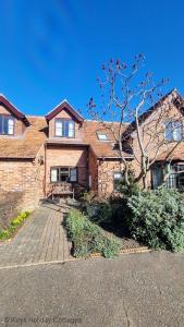 une maison en briques avec un banc devant elle dans l'établissement The Den, à Sheringham