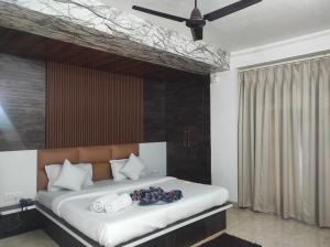 a bedroom with a large bed with a ceiling at HOTEL SG HUB TOWER in Margherita