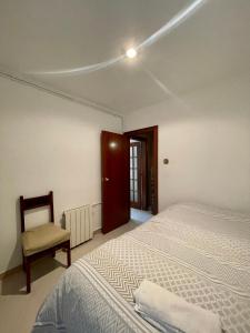 1 dormitorio con 1 cama y 1 silla en 3 bedrooms flat near of the beach en Barcelona
