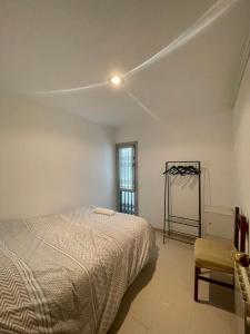 1 dormitorio con 1 cama, 1 silla y 1 ventana en 3 bedrooms flat near of the beach en Barcelona