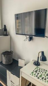 a flat screen tv on a wall above a desk at Biała Perła Czarna Góra Resort Apartament 102 in Sienna