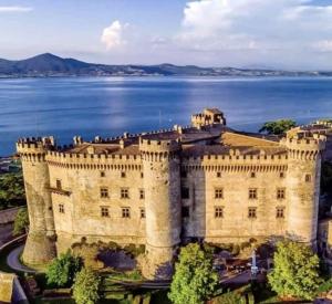 Alloggio turistico Il Tiglio في كانالي مونتيرانو: قلعة قديمة مع بحيرة في الخلفية