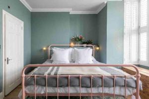 a bedroom with a metal bed with blue walls at Walpole View - Pet Friendly in Margate